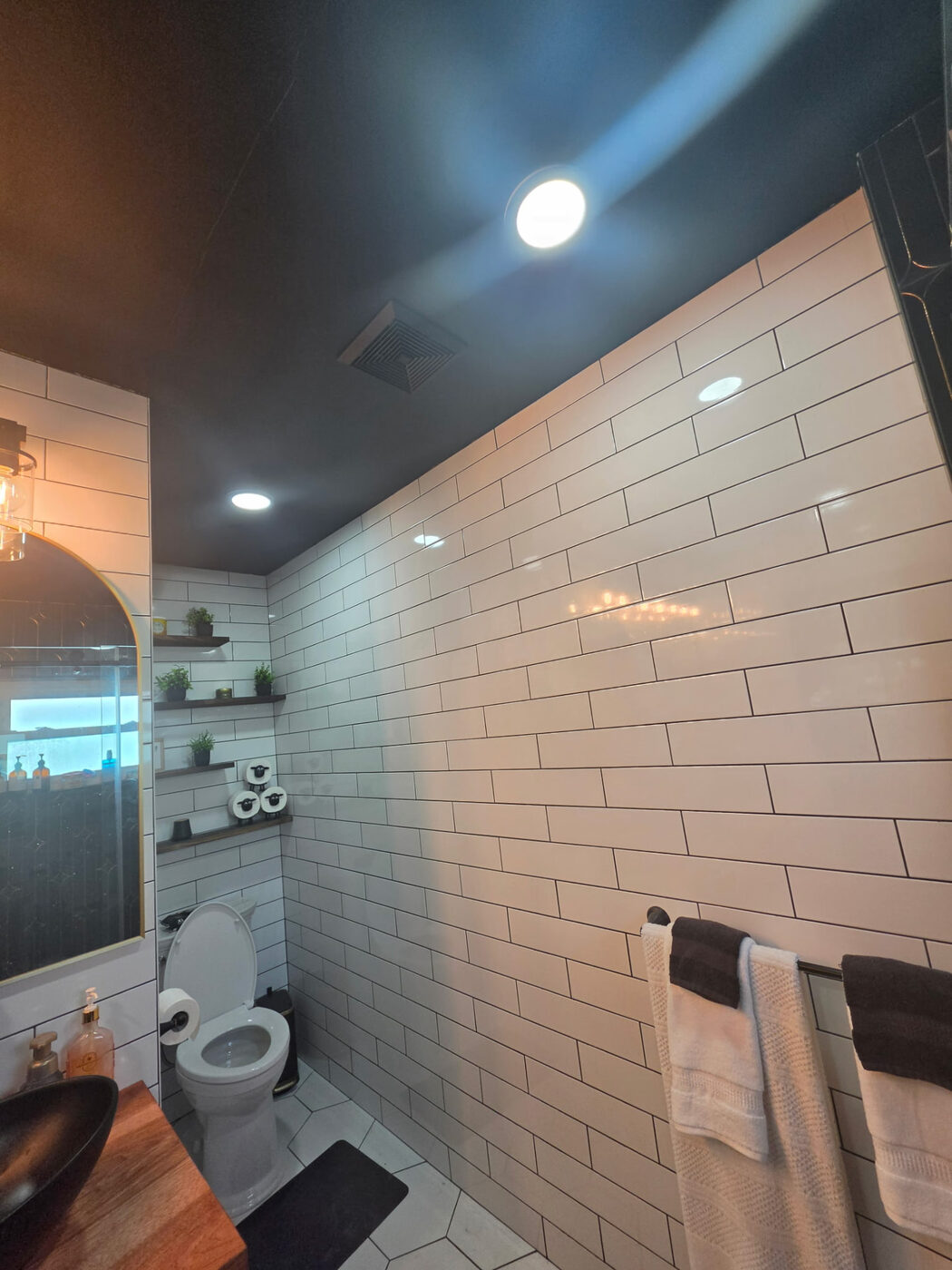 Subway tile bathroom with slim LED ceiling fixtures and exhaust fan