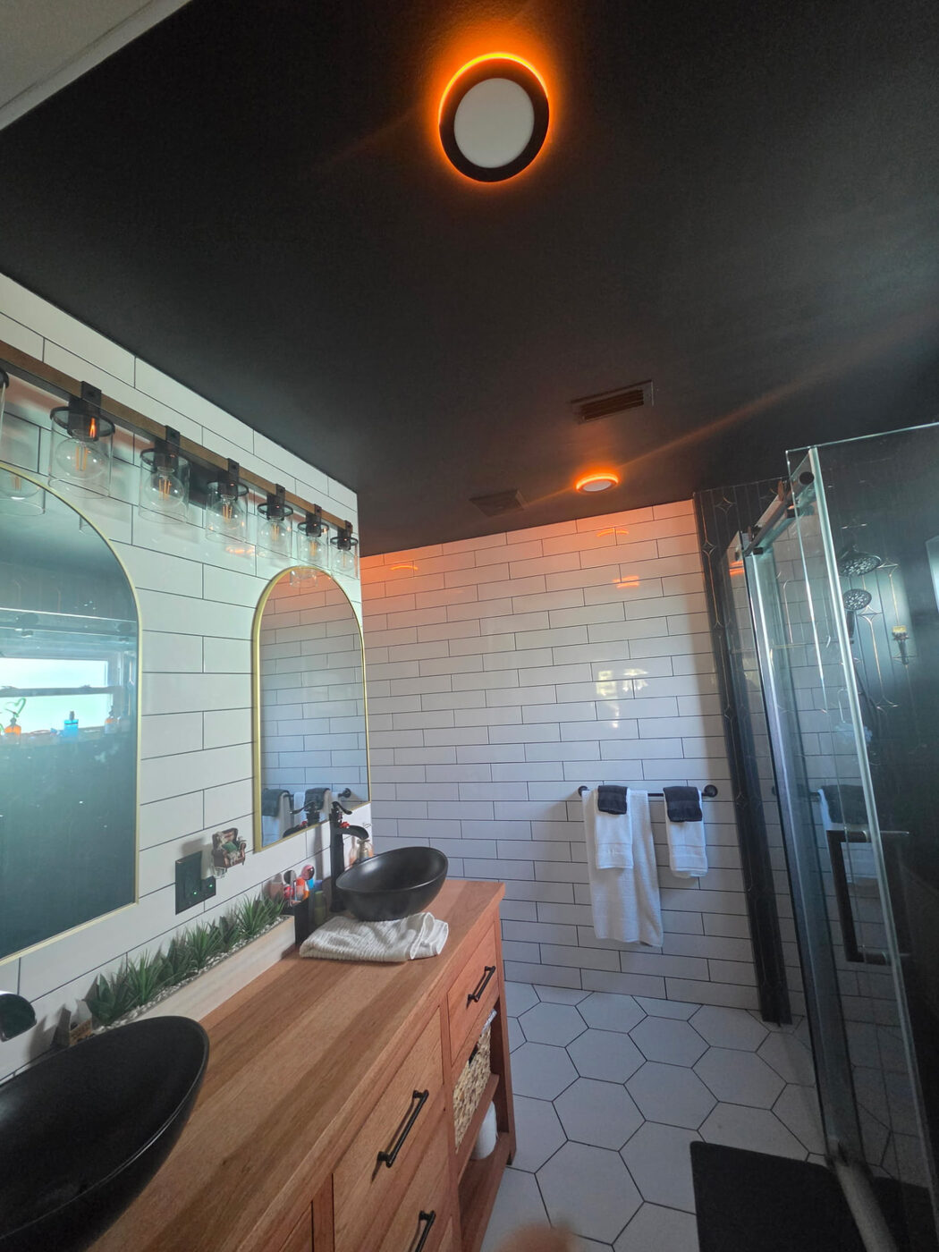 Bathroom with warm orange back-lit ceiling lights and vanity fixture