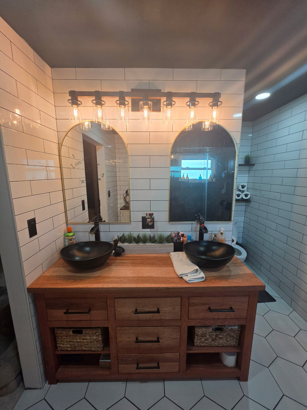 Master bathroom remodel with vanity lighting installed above dual mirrors