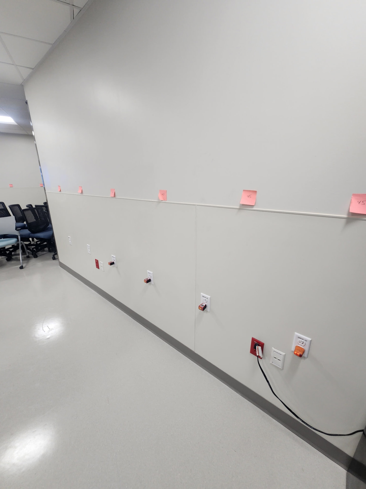 Corridor wall with a row of newly installed receptacles and devices